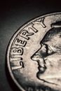 From above closeup of silver metal cent with liberty inscription and profile of American president placed on dark surface
