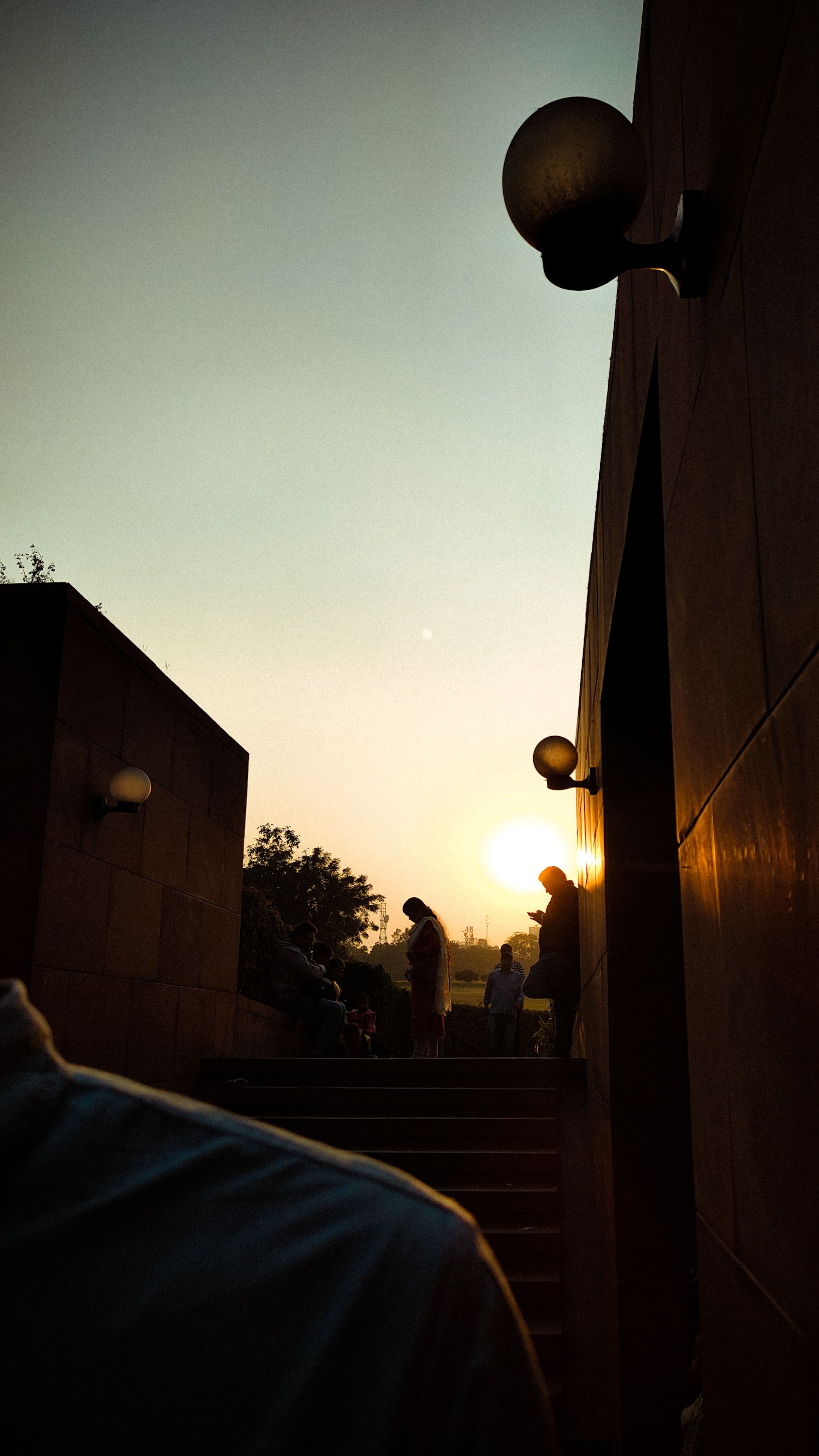 A dramatic silhouette of people on stairs during sunset, capturing urban life moments and golden hour lighting.