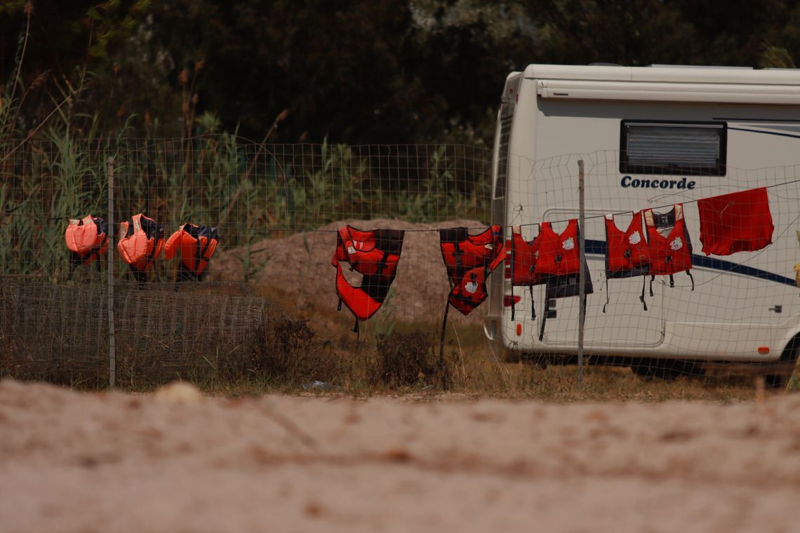 Bright life jackets arranged near an outdoor beach setting