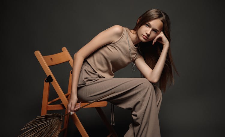 Beautiful Brunette Woman Wearing Dress Sitting On Chair