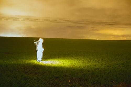 Man in a White Overalls Standing in the Field 