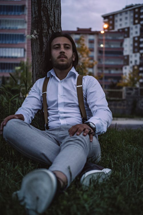 Man in White Long Sleeves Sitting Under the Tree 