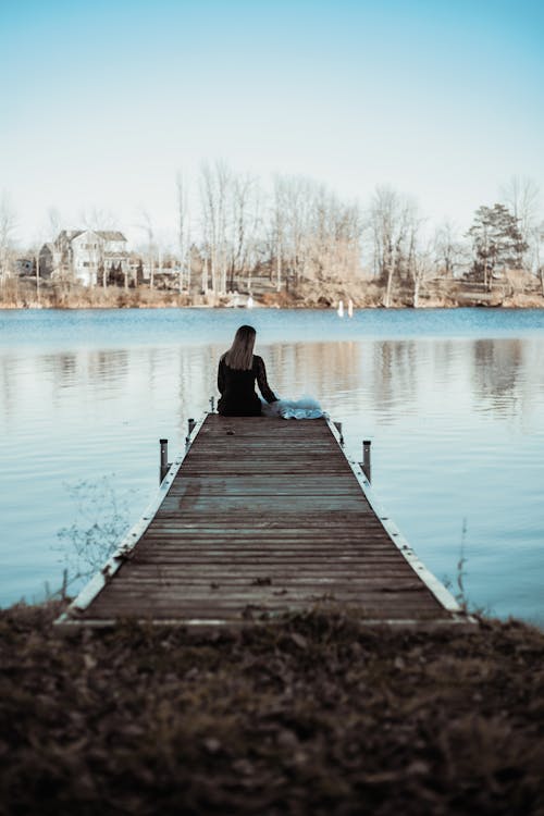 Woman Sitting on a Viewing Deck on Riverside