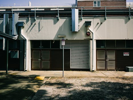 Exterior view of an industrial building facade on a sunny city street.
