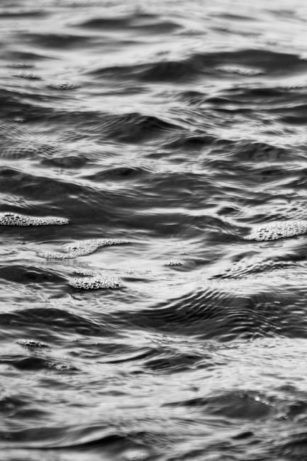 Grayscale image capturing the abstract texture of water with gentle ripples.