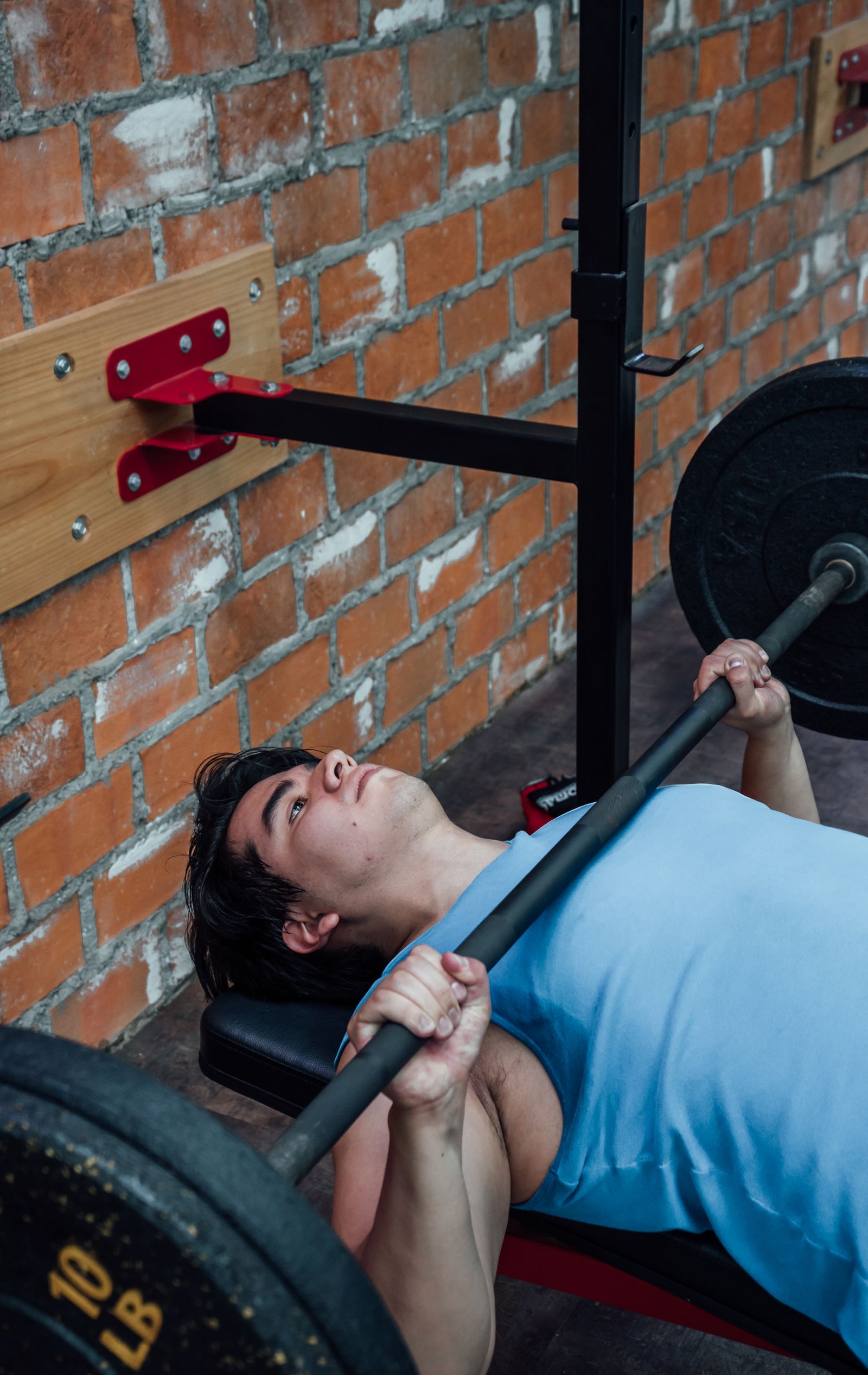 Athlete performing a barbell bench press in a gym
