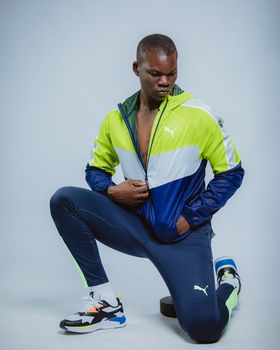 Stylish athlete posing in vibrant sportswear against a minimalist background.