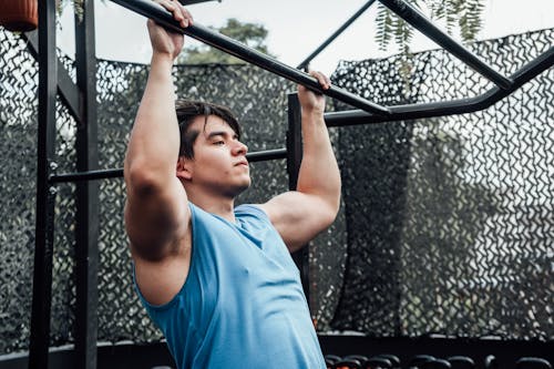 A Man in Blue Tank Top Doing Pull Ups