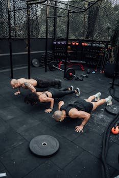 Three adults performing push-ups at an outdoor gym in Mexico City, showcasing strength and teamwork.