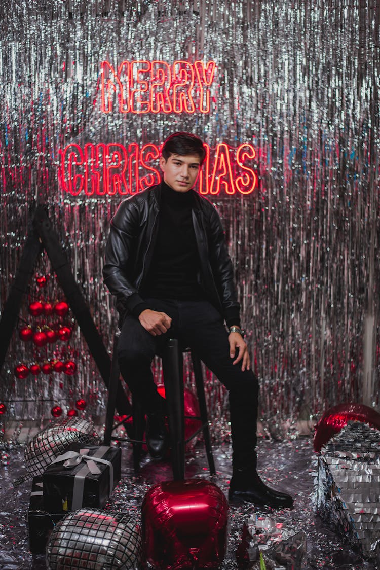 Man Sitting On Chair In Glitter Christmas Decorations