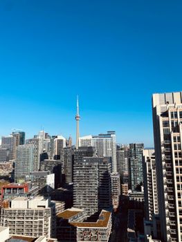 A vibrant view of Toronto's skyline under a clear blue sky, showcasing the iconic CN Tower.