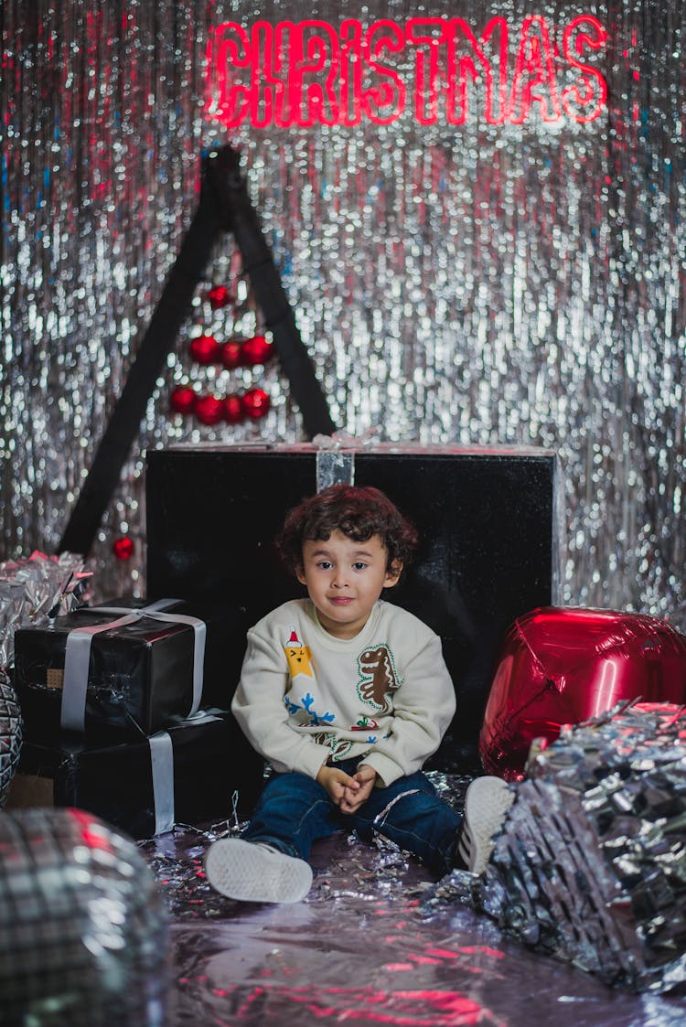 Boy Sitting Between Christmas Gifts