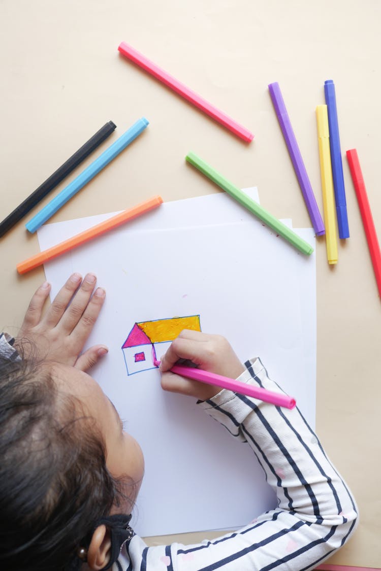 A Girl Drawing On White Paper