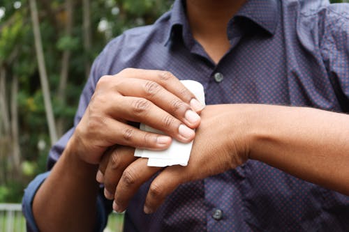A Person Wiping Hands in Close-up Photography