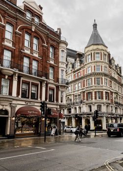 Captivating London street view featuring iconic architecture, bustling with people and classic vehicles.
