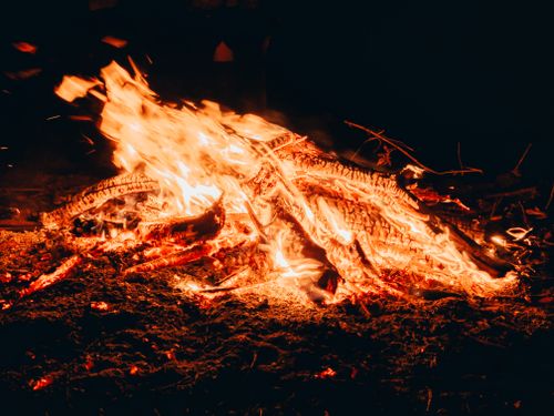 Free A detailed view of a vibrant campfire with blazing flames and smoldering firewood. Stock Photo