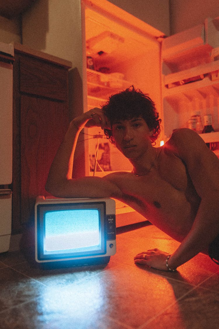 Shirtless Man Using Retro Tv On Floor