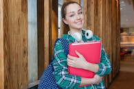 Woman Standing in Hallway While Holding Book