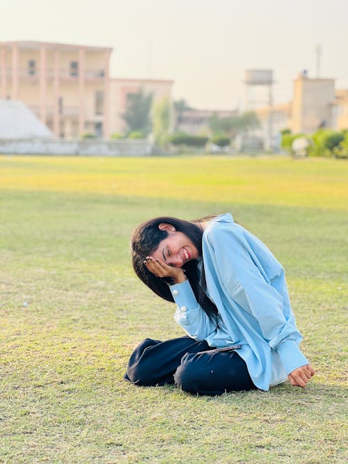 Free Smiling Brunette Sitting on Grass Stock Photo