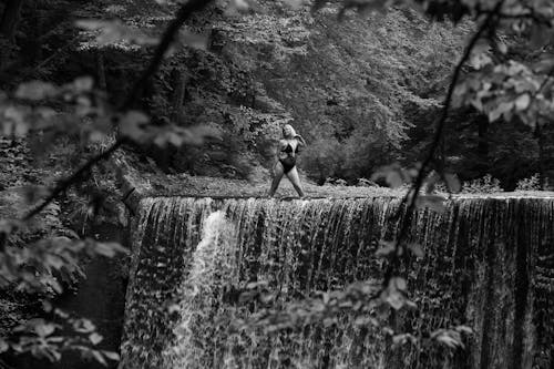 A Woman Standing on the Top of a Waterfall