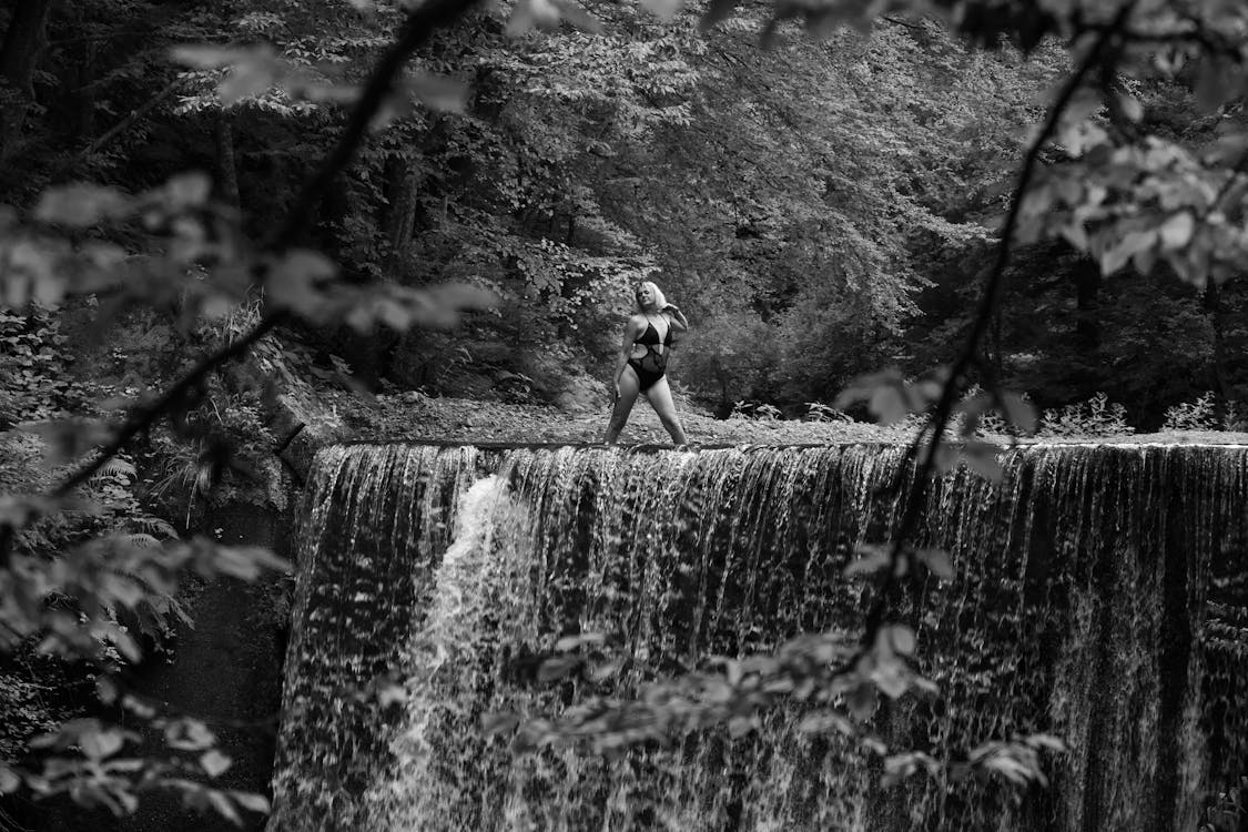 A Woman Standing on the Top of a Waterfall