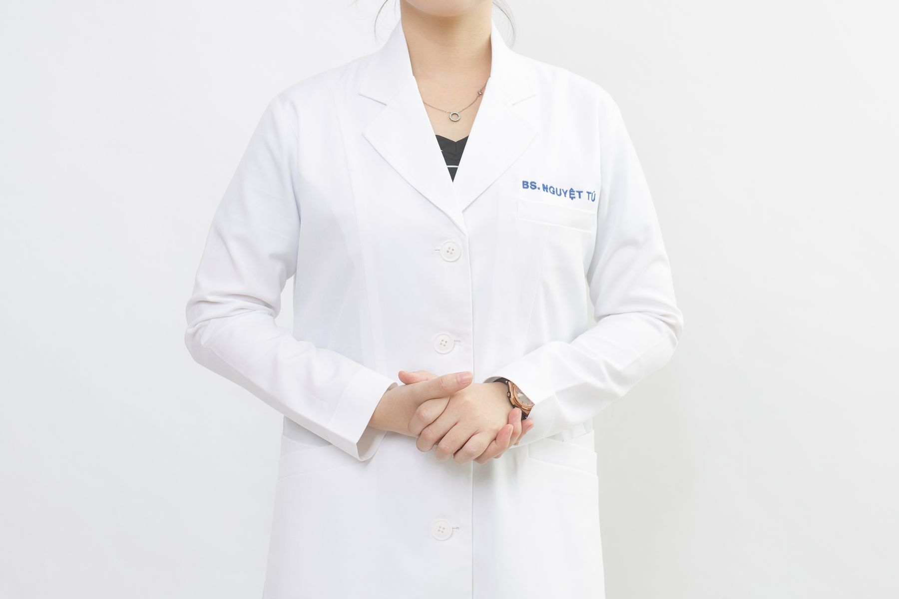 Confident cosmetic physician in a white coat in a clean private-practice consultation setting