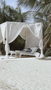 Serene white cabana with sunloungers on a tropical beach in Lamu, Kenya, perfect for a luxury summer vacation.