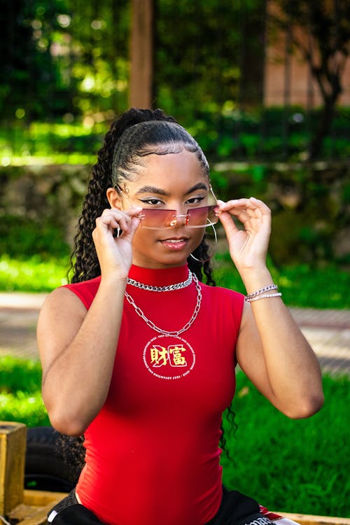 Woman in Red Turtleneck Holding Her Sunglasses