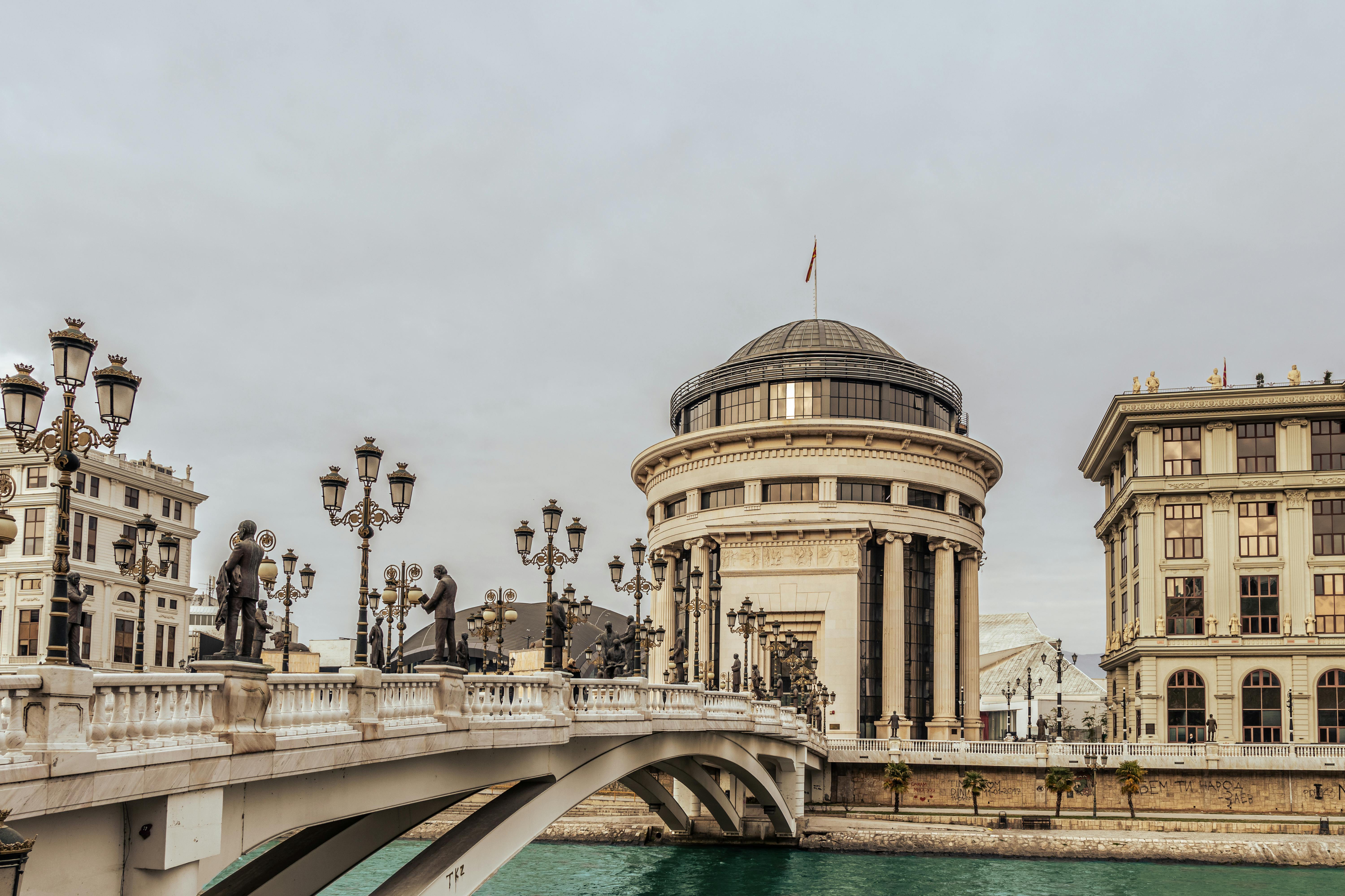 Historic bridge and architecture in Skopje, showcasing cultural landmarks and river views.