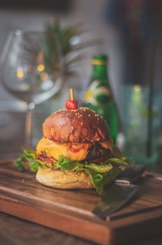 Mouthwatering cheeseburger with fresh lettuce, served on a wooden board. Perfect for food lovers.