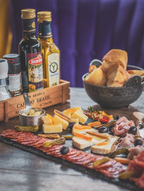 Free Gourmet charcuterie board with cheeses, meats, oils, and bread, ideal for foodies. Stock Photo