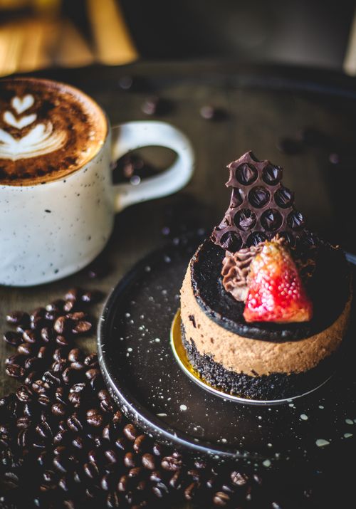 Free Indulge in a rich chocolate cake topped with strawberries and paired with a cappuccino. Stock Photo