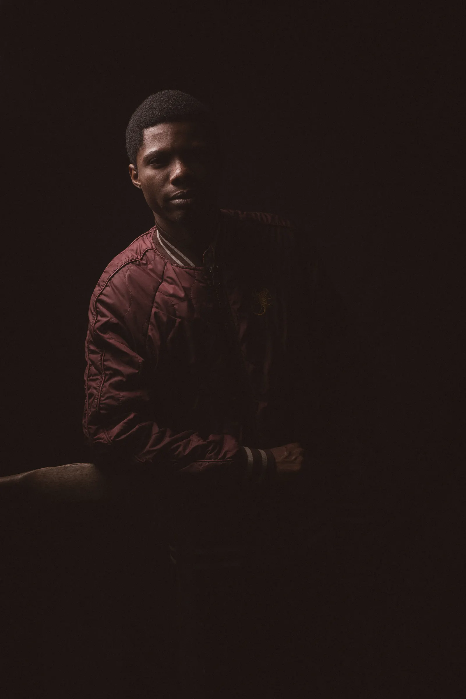 Man in a red jacket in a dark studio