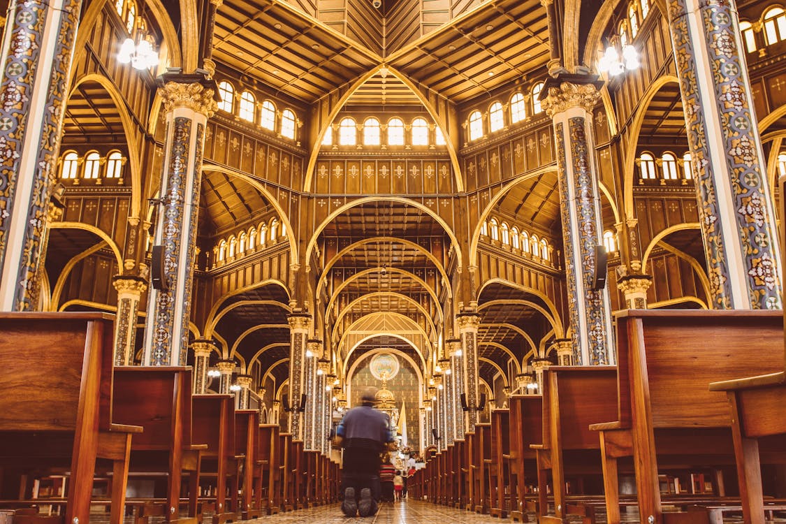 Free A man is sitting in a church with a cross Stock Photo