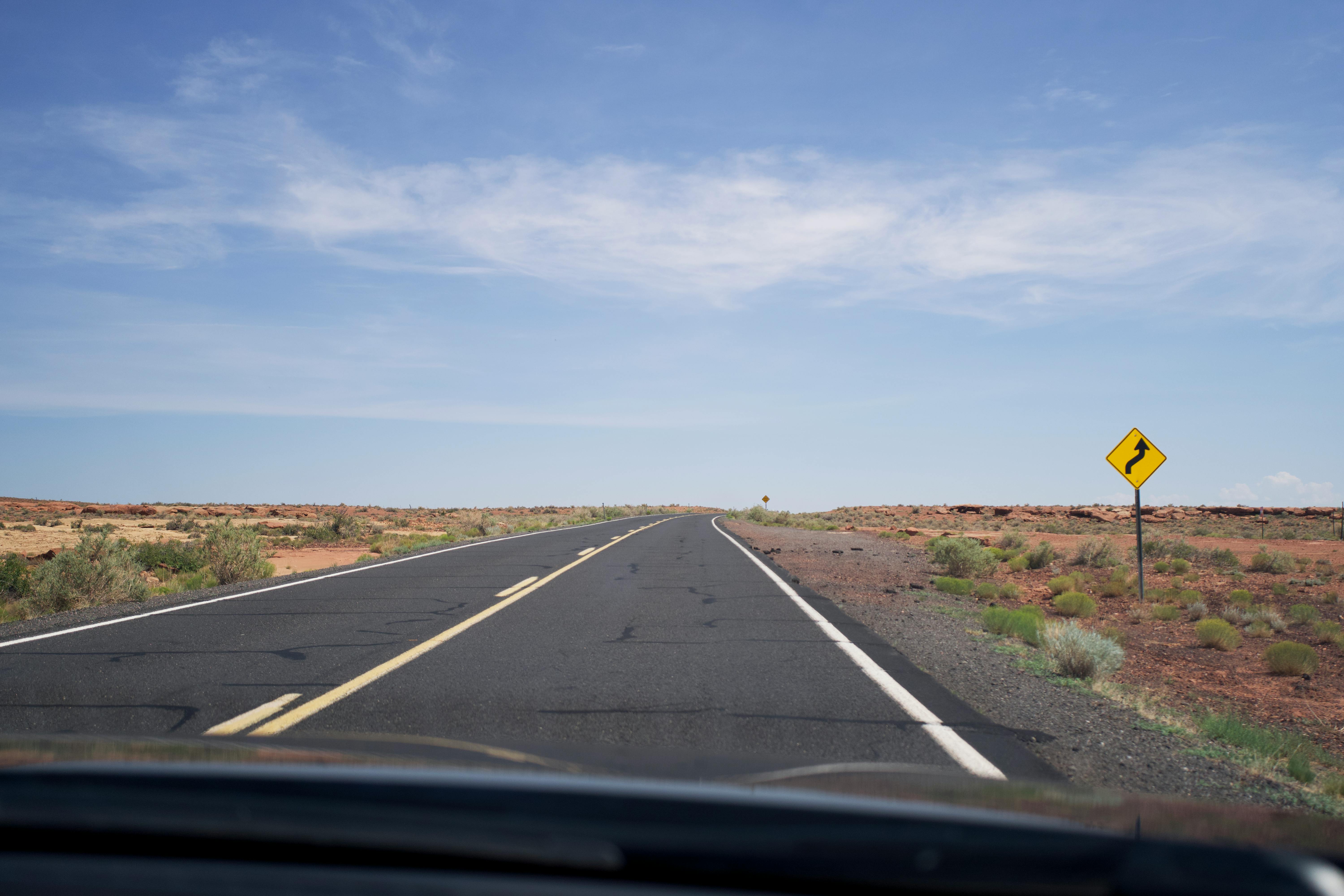 driving on an empty asphalt road through the desert