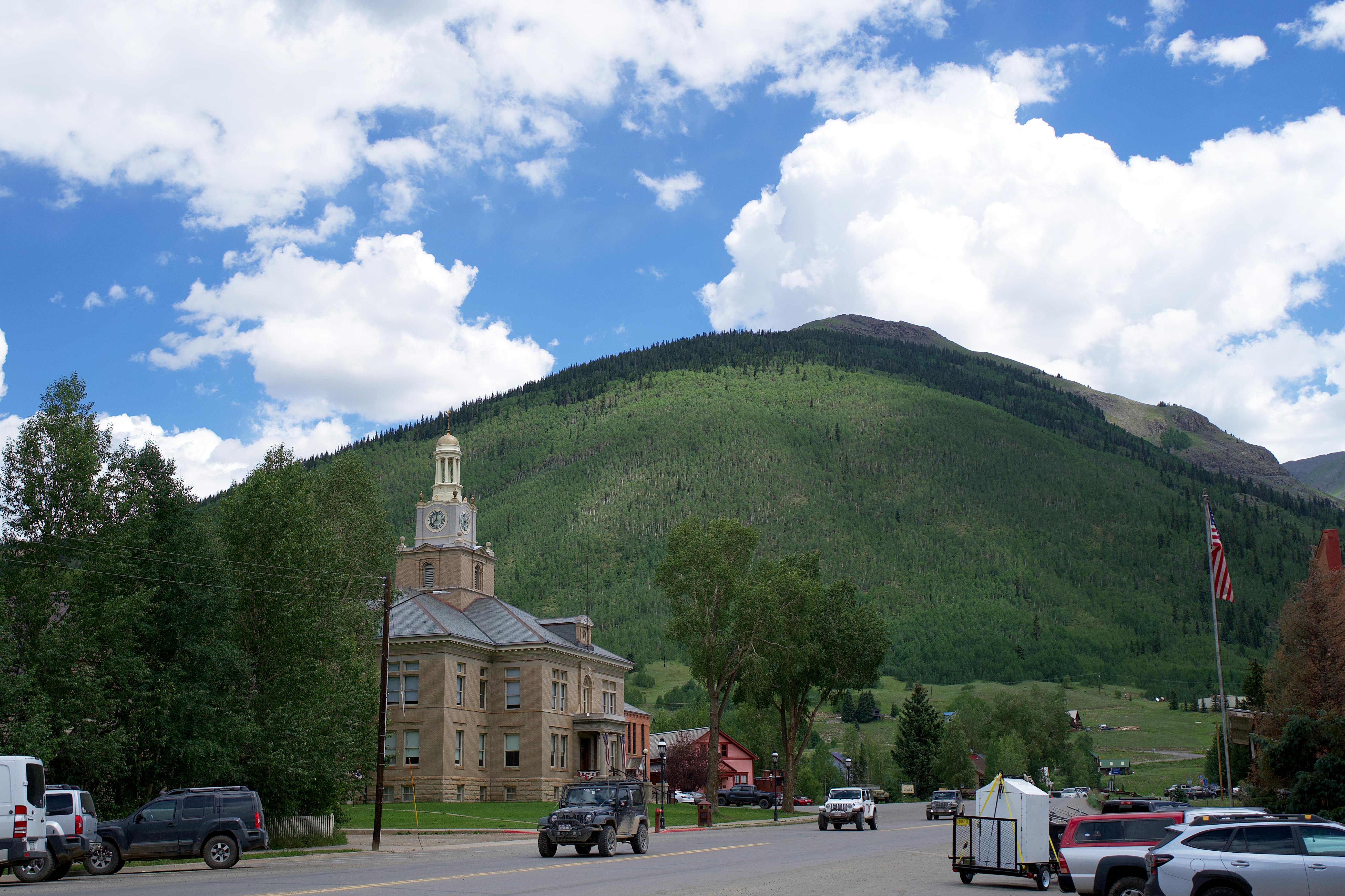 san juan county courthouse with a green mountain in the background