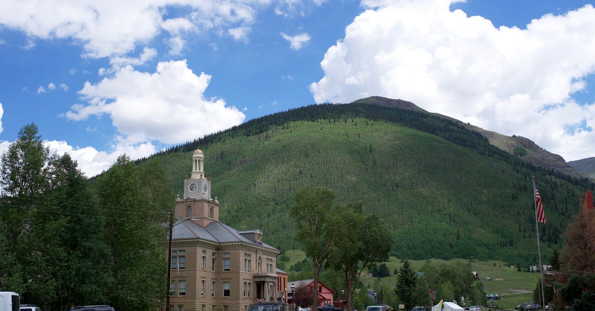 Scenic view of the San Juan County Courthouse with mountainous backdrop in Silverton, Colorado.