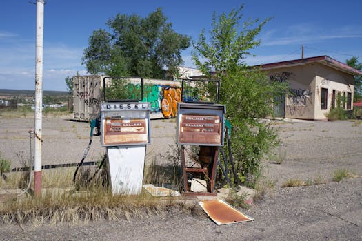 Explore the decay of an abandoned gas station with rusted fuel pumps and grafitti-covered walls.