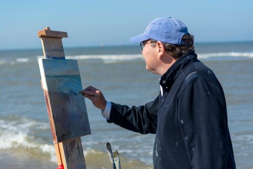 Free An artist painting a seascape on the beach with an easel, showcasing creative inspiration. Stock Photo