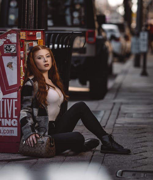 Woman Sitting on Sidewalk