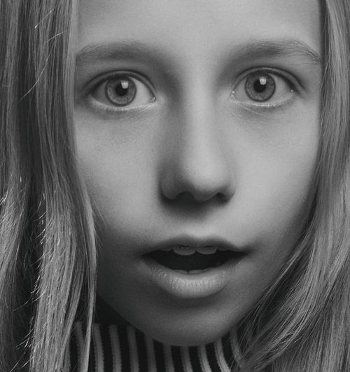 Free Close-up grayscale portrait of a surprised girl with wide eyes and open mouth. Stock Photo