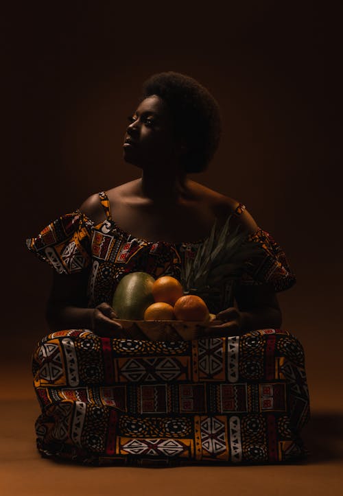Photo of a Woman Holding a Plate with Fruits