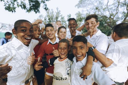 Free A group of smiling teenagers enjoying a sunny day outdoors, showcasing friendship and diversity. Stock Photo