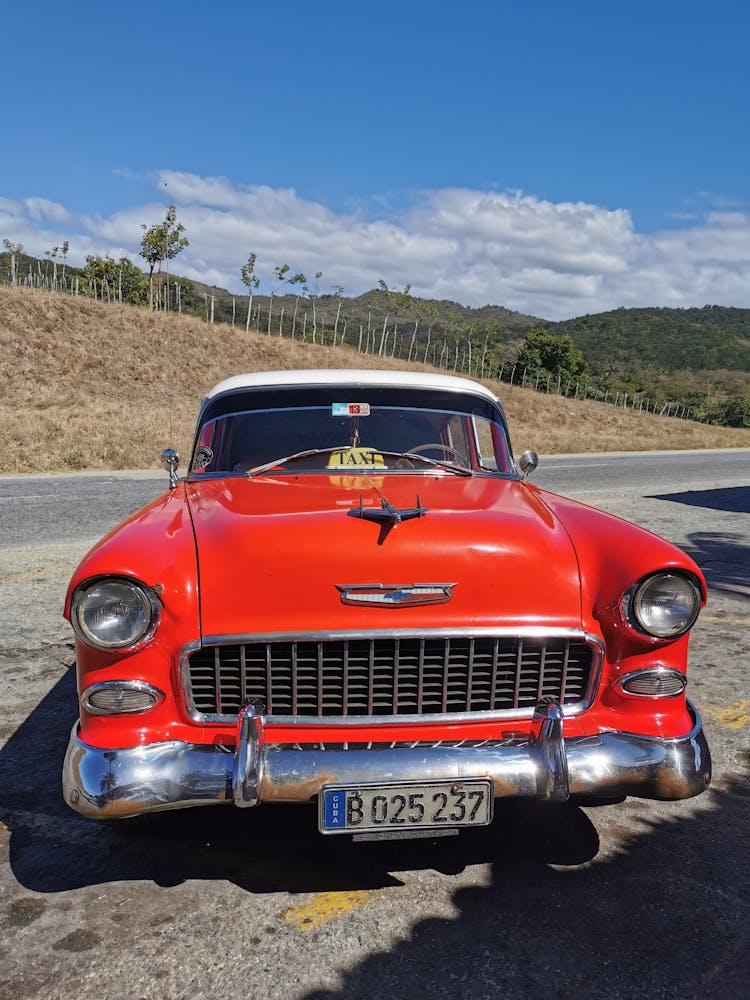 Red Car Parked On Gray Concrete Road