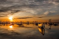 日落时船的宁静场景，平静的水面上的美丽倒影，捕捉到宁静的氛围