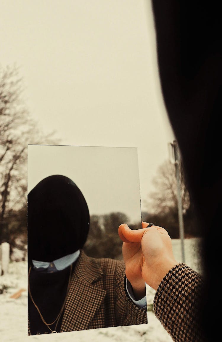 Man With Covered Face Reflecting In A Mirror