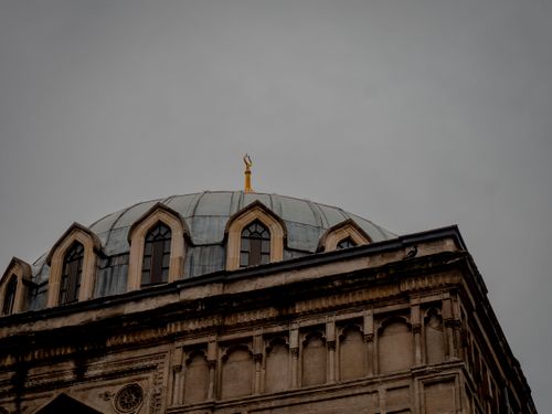 Free Dramatic baroque architectural dome beneath a cloudy sky, featuring ornate detailing and elegant windows. Stock Photo