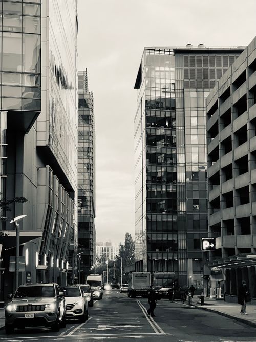 Free Dynamic city street view in grayscale with modern buildings and vehicles. Stock Photo