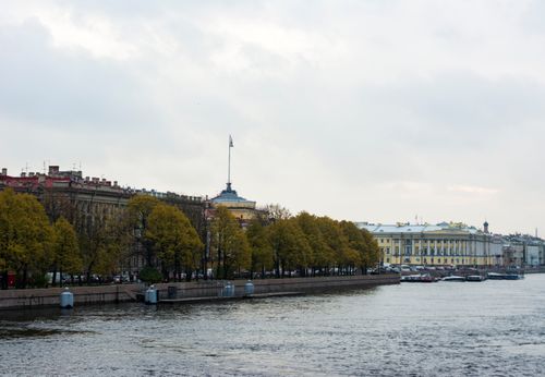Free Riverfront view in Saint Petersburg with historic buildings and autumn trees reflecting in the water. Stock Photo