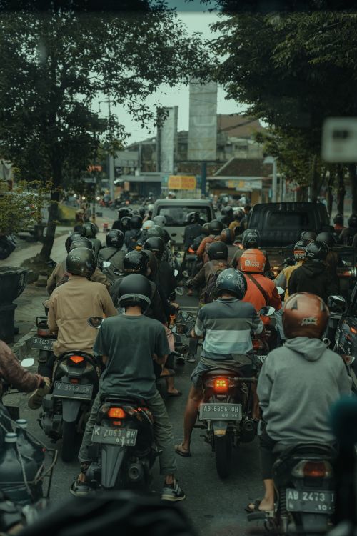 Free Motorcycles and cars stuck in traffic on a street in Yogyakarta, Indonesia, during the daytime. Stock Photo